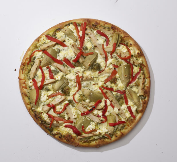 Overhead View of a Whole Specialty Pizza with Pesto Sauce, Sliced Artichoke Hearts, Roasted Red Peppers, Feta Cheese and Grilled Chicken Toppings, on a White Background for Isolation