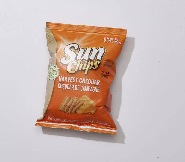 Overhead View of a Snack Bag of Harvest Cheddar Flavoured Sun Chips Multigrain Snacks, on a White Background for Isolation