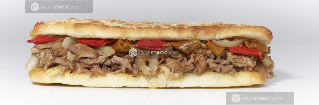 An Italian Porchetta Sandwich with Hot Peppers and Sautéed Onions on Ciabatta Bread, on a White Background for Isolation