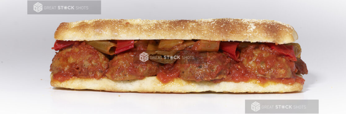 An Italian Meatball Sandwich with Hot Peppers and Marinara Sauce on Ciabatta Bread, on a White Background for Isolation