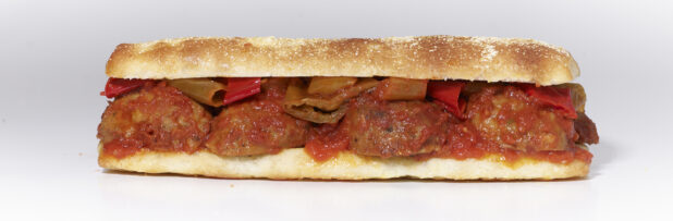 An Italian Meatball Sandwich with Hot Peppers and Marinara Sauce on Ciabatta Bread, on a White Background for Isolation