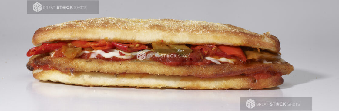 An Italian Cutlet Sandwich with Hot Peppers, Marinara Sauce and Cheese on Ciabatta Bread, on a White Background for Isolation