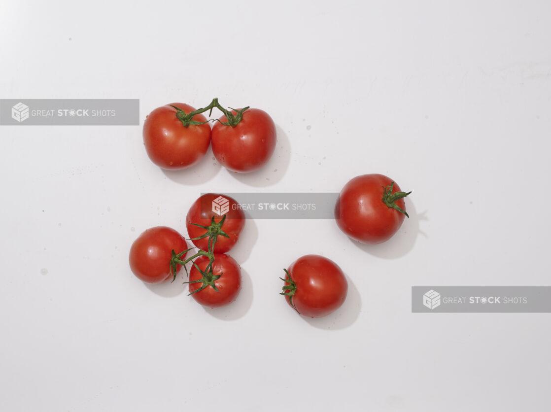 Overhead View of a Cluster of Whole Tomatoes on the Vine, on a White Background for Isolation