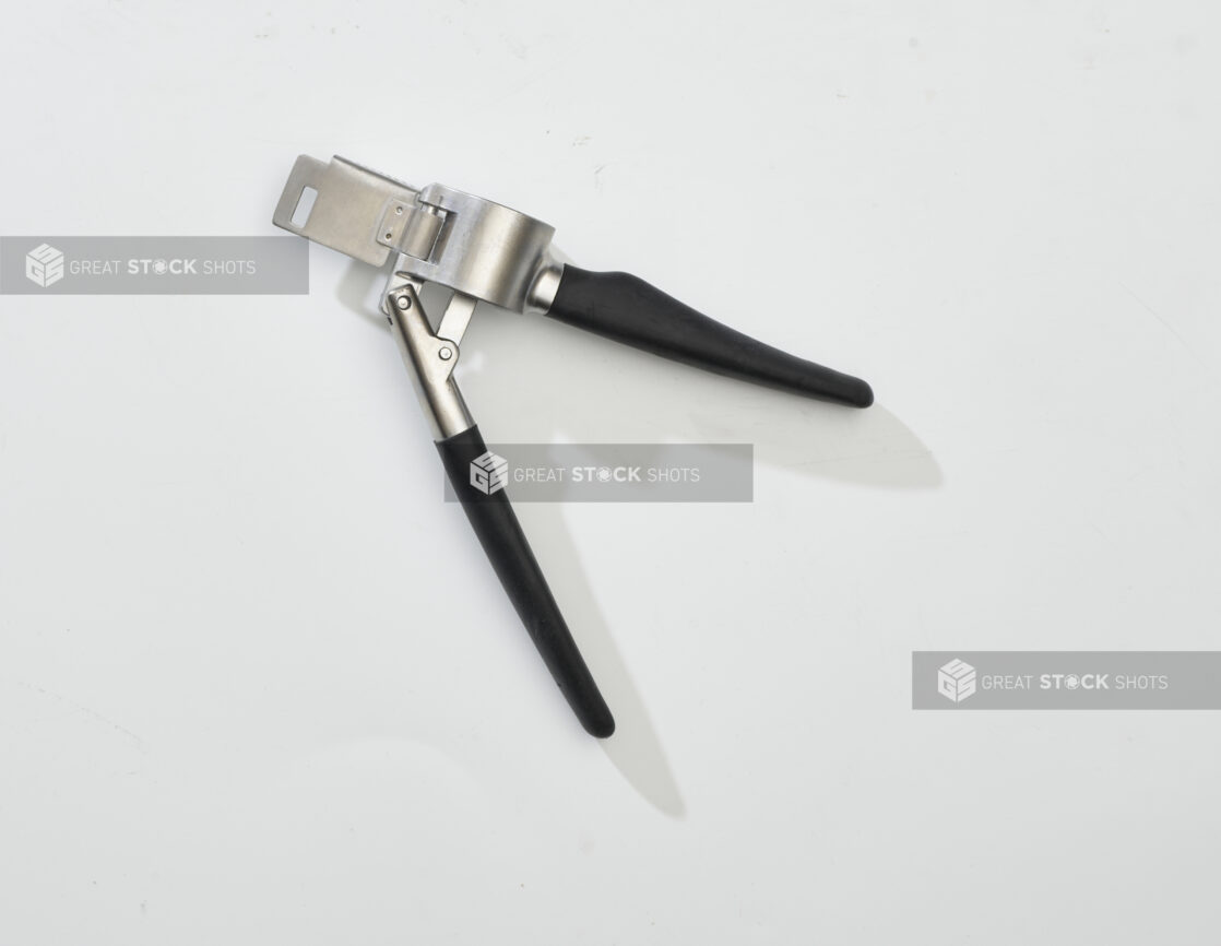 Overhead View of a Metal Garlic Press with a Black Handle, on a White Background for Isolation