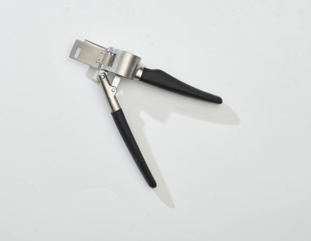 Overhead View of a Metal Garlic Press with a Black Handle, on a White Background for Isolation