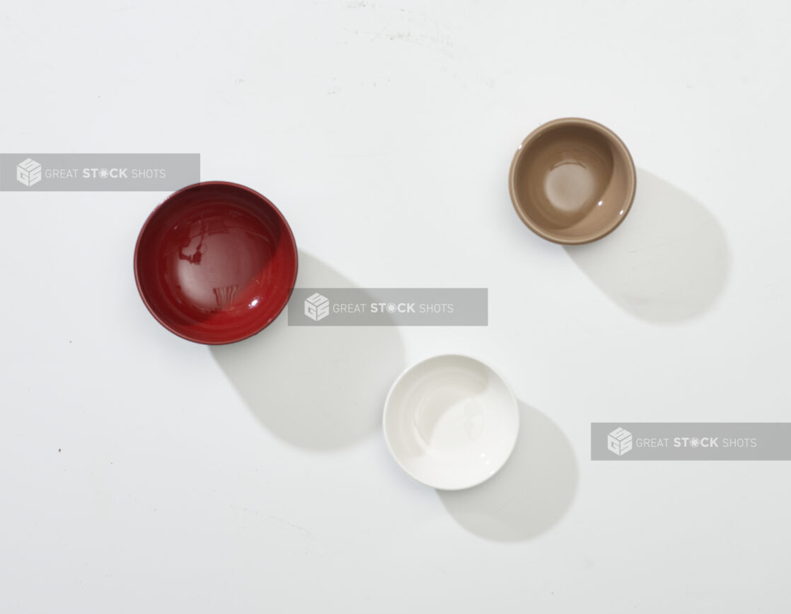 Overhead View of Red, White and Brown Round Ceramic Dishes, on a White Background for Isolation