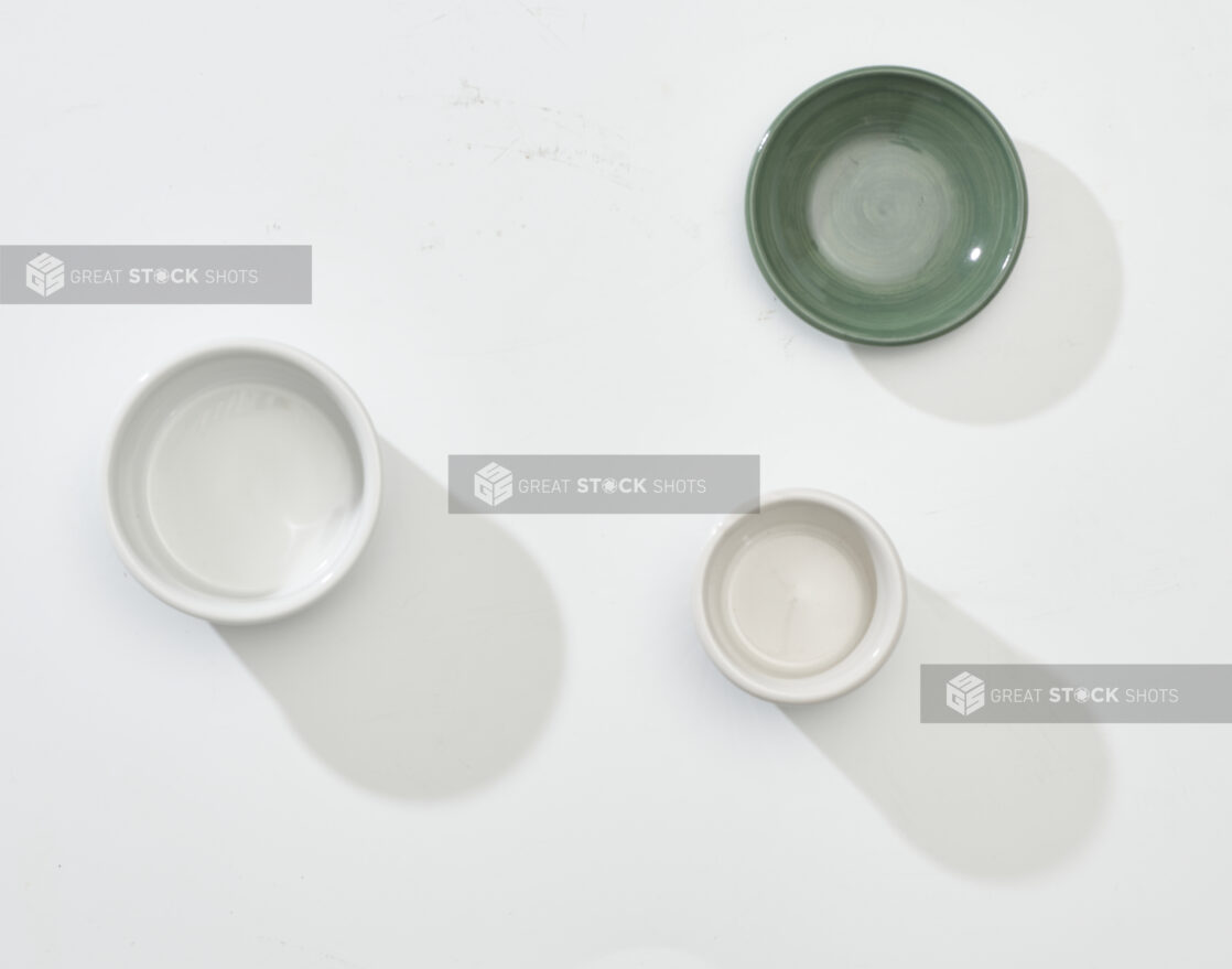 Overhead View of Green, White and Beige Round Ceramic Dishes, on a White Background for Isolation