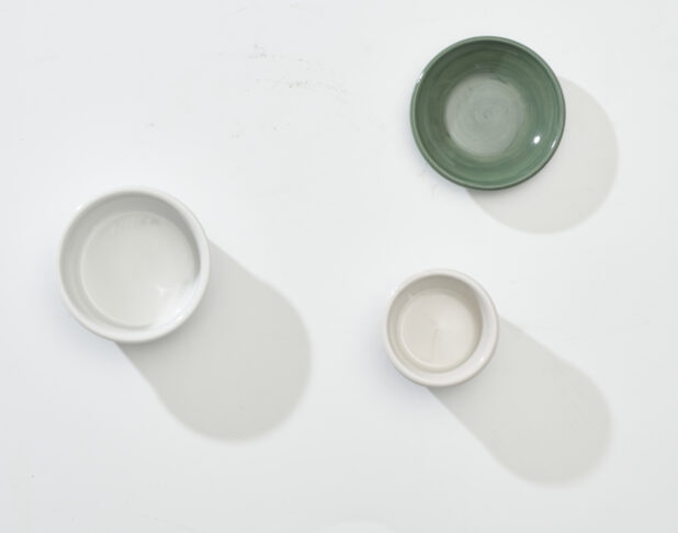 Overhead View of Green, White and Beige Round Ceramic Dishes, on a White Background for Isolation