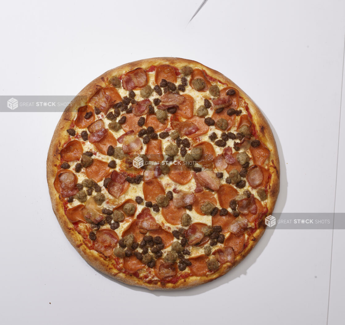 Overhead View of a Whole Meat Lovers Pizza with Pepperoni, Bacon, Italian Sausage and Ground Beef, on a White Background for Isolation