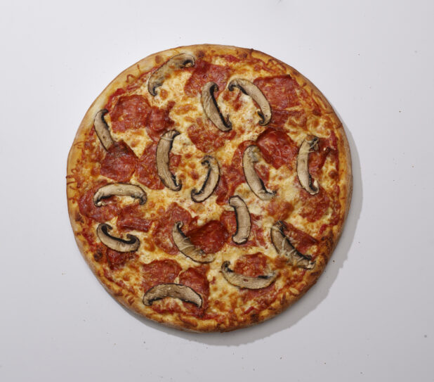 Overhead View of a Whole Specialty Pizza with Spicy Soppressata Salami and Portobello Mushroom Toppings, on a White Background for Isolation