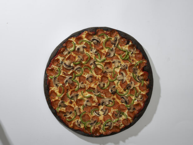 Overhead View of a Whole Charcoal-Infused Pizza with Pepperoni, Green Peppers and Mushroom Toppings, on a White Background for Isolation