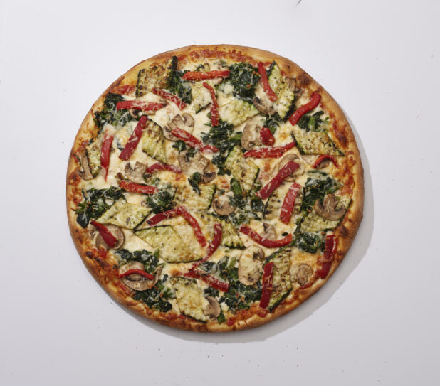 Overhead View of a Whole Specialty Pizza with Roasted Zucchini, White Mushrooms, Roasted Red Peppers, Sautéed Spinach and Parmigiana Cheese Toppings, on a White Background for Isolation
