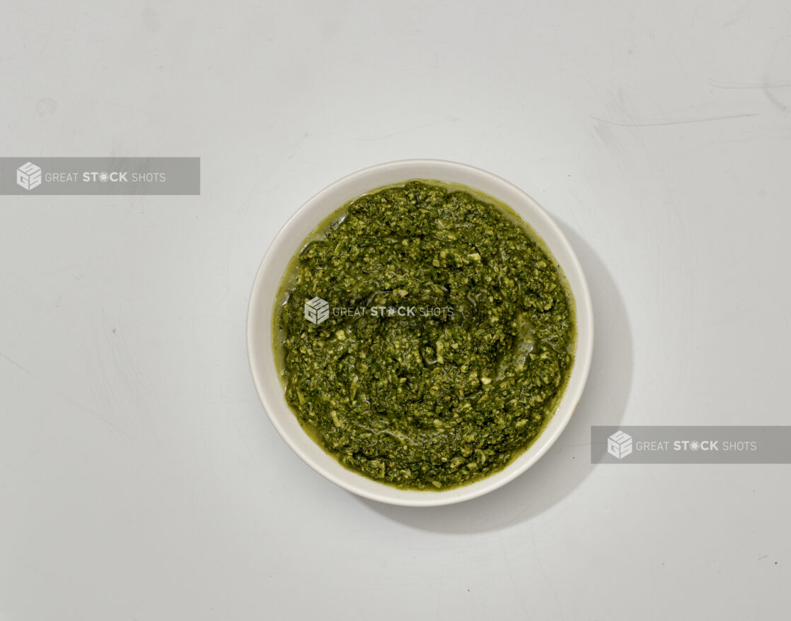 Overhead View of Pesto Sauce in a White Ceramic Ramekin, on a White Background for Isolation