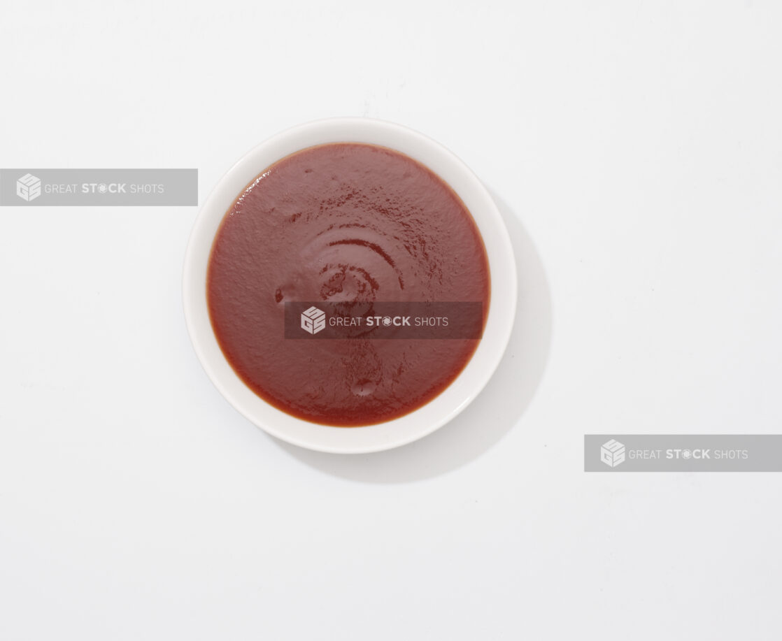 Overhead View of a Small Round Ceramic Bowl of BBQ Sauce, on a White Background for Isolation