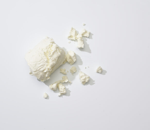 Crumbled goat cheese on a white background