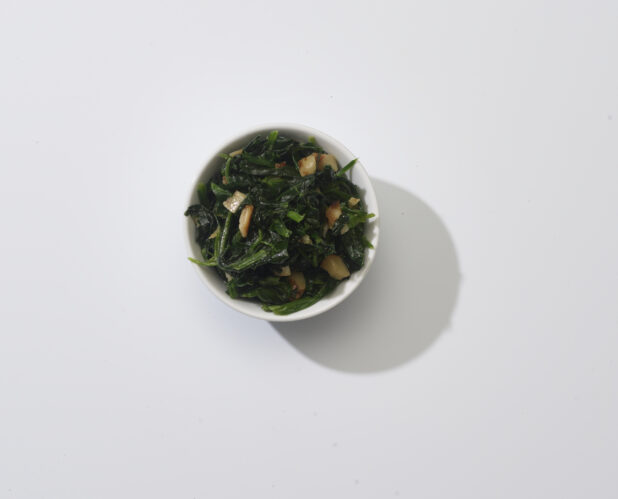 Sauteed spinach and garlic in a white bowl