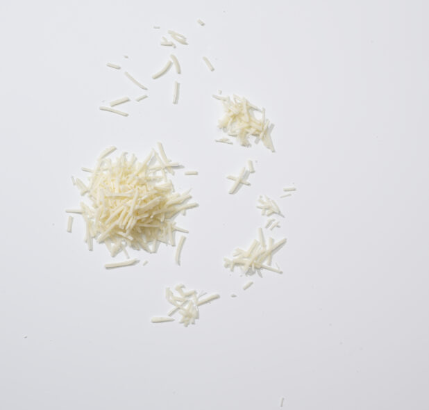 Coarsely grated Parmesan on a white background