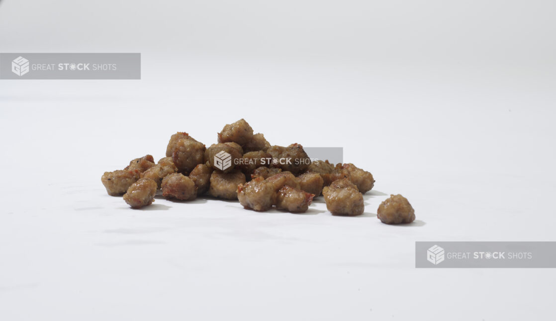 Cooked crumbled sausage on a white background