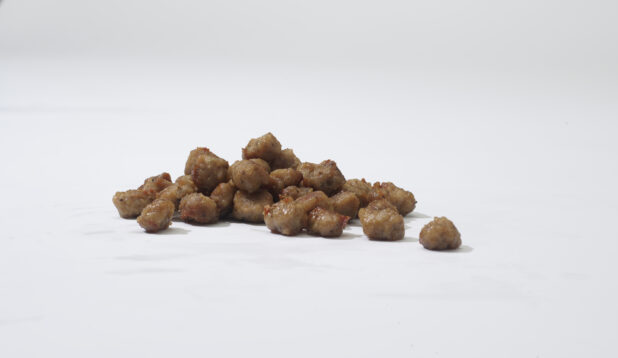 Cooked crumbled sausage on a white background