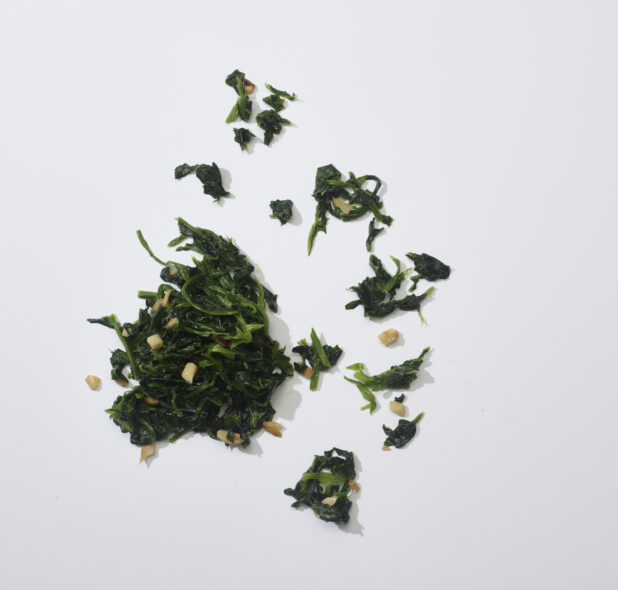 Sauteed spinach with garlic isolated on a white background