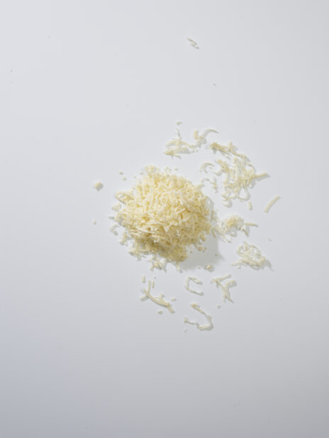 Grated white cheese on a white background