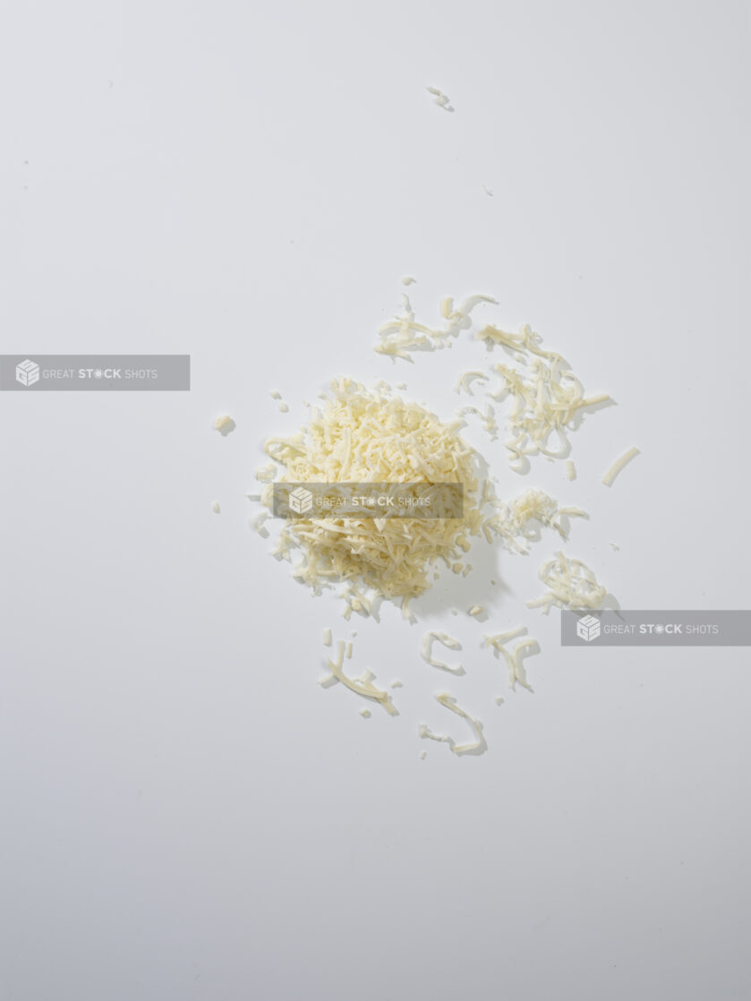 Grated white cheese on a white background