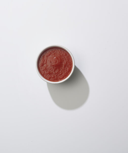 A bowl of tomato sauce on a white background