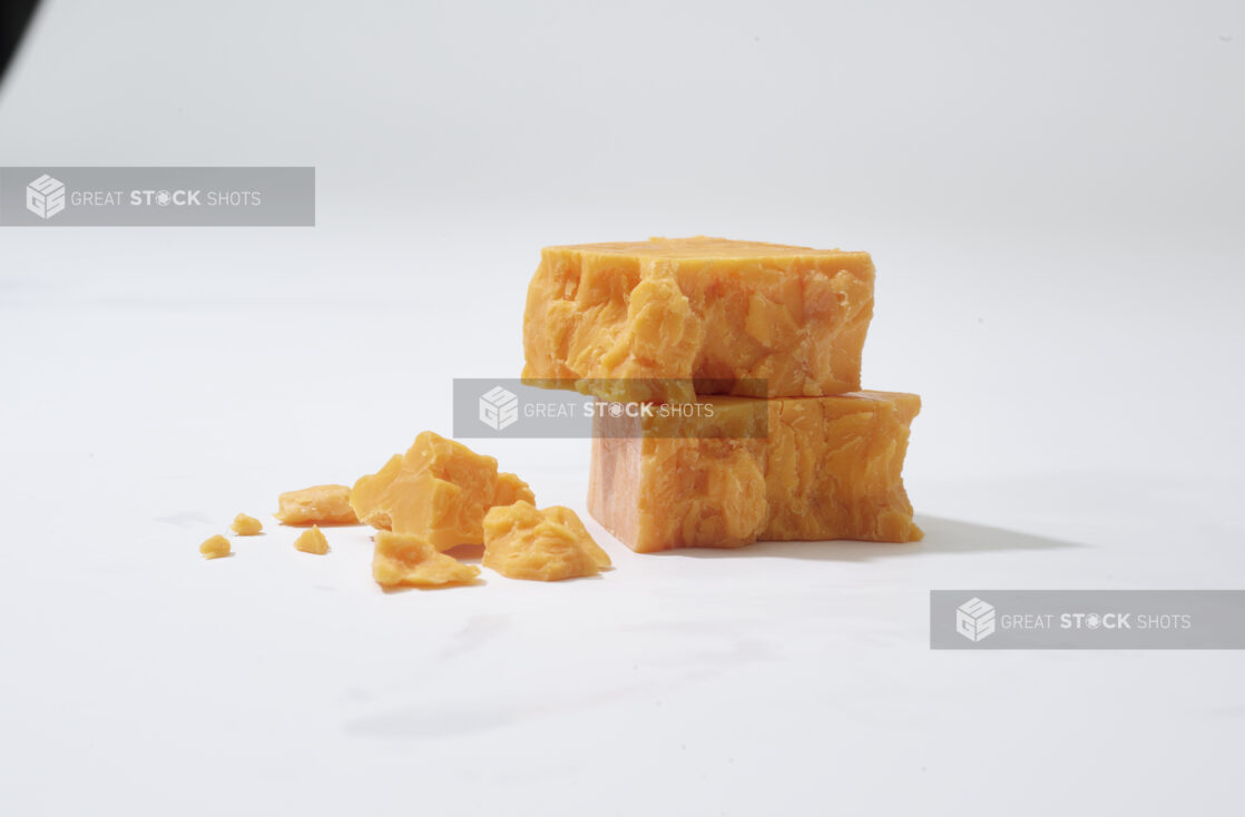 Chunks of cheddar cheese on a white background