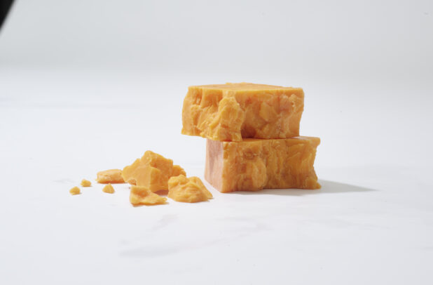 Chunks of cheddar cheese on a white background