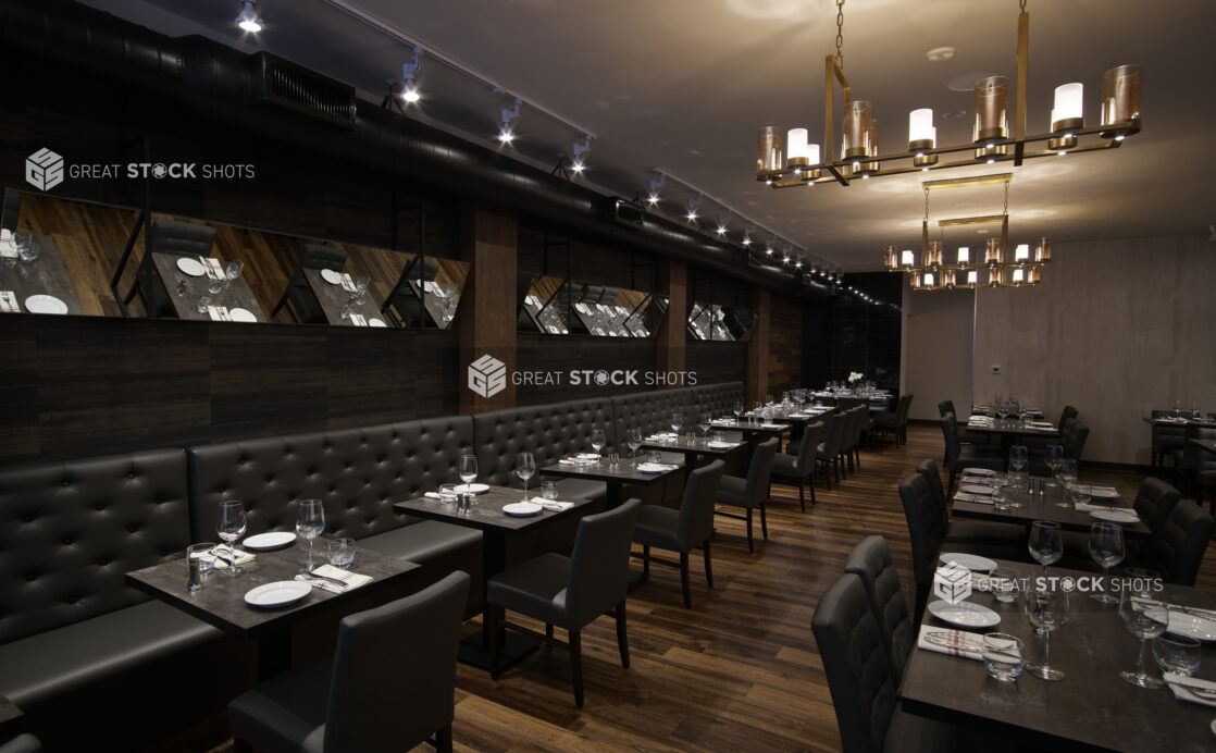 An elegant restaurant steakhouse with modern Chandeliers and dark upholstery