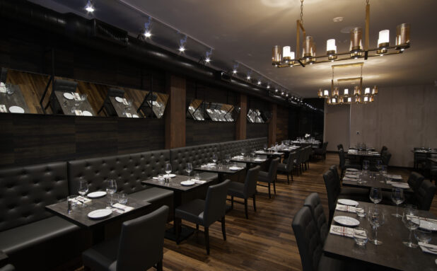 An elegant restaurant steakhouse with modern Chandeliers and dark upholstery