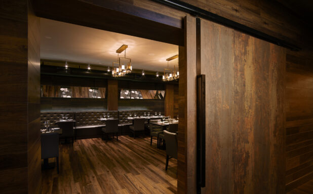 Dark wood sliding door opening to an elegant dining room