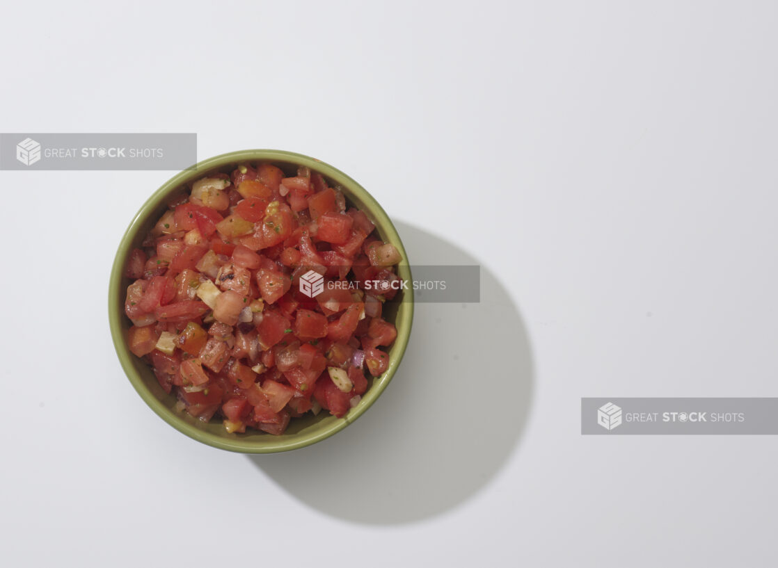 A bowl of bruschetta mix on a white background