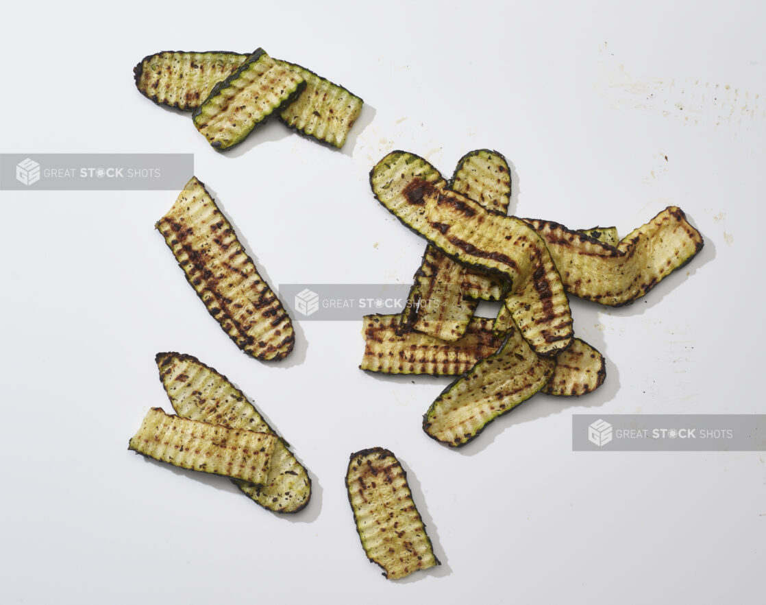 Sliced grilled zucchini on a white background