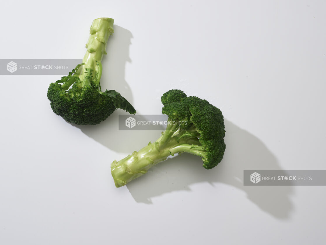 Spears of fresh broccoli on a white background