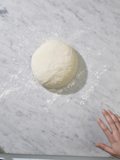A ball of raw dough on a marble background