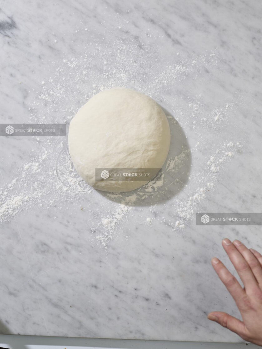 A ball of raw dough on a marble background