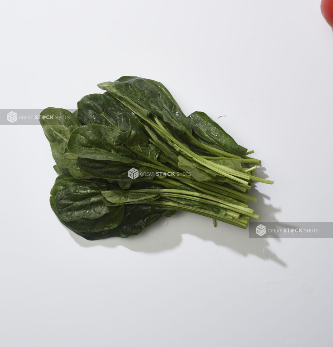 A bunch of fresh spinach on a white background