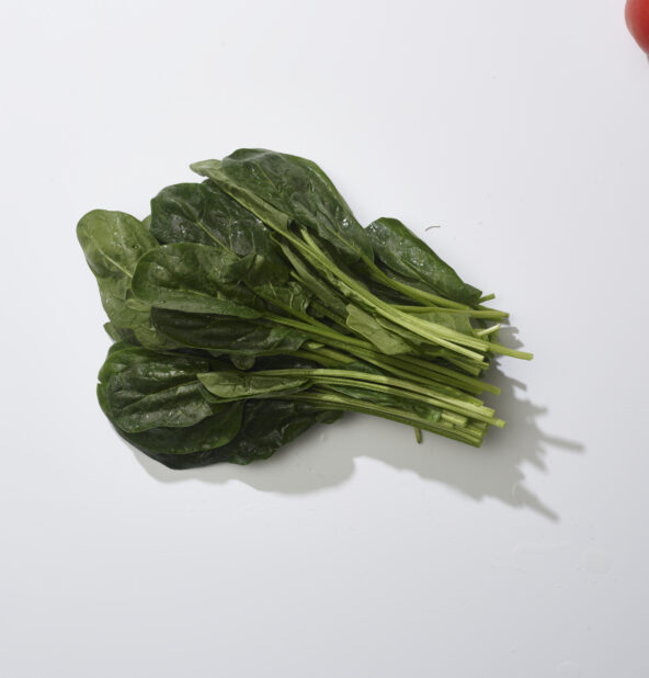 A bunch of fresh spinach on a white background