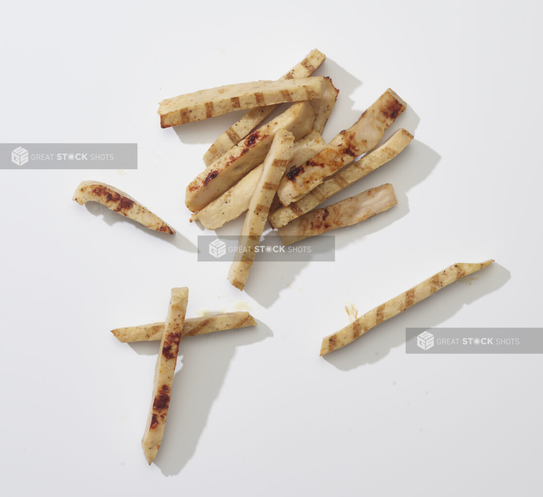 Sliced grilled chicken on a white background