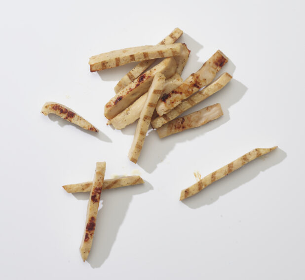 Sliced grilled chicken on a white background