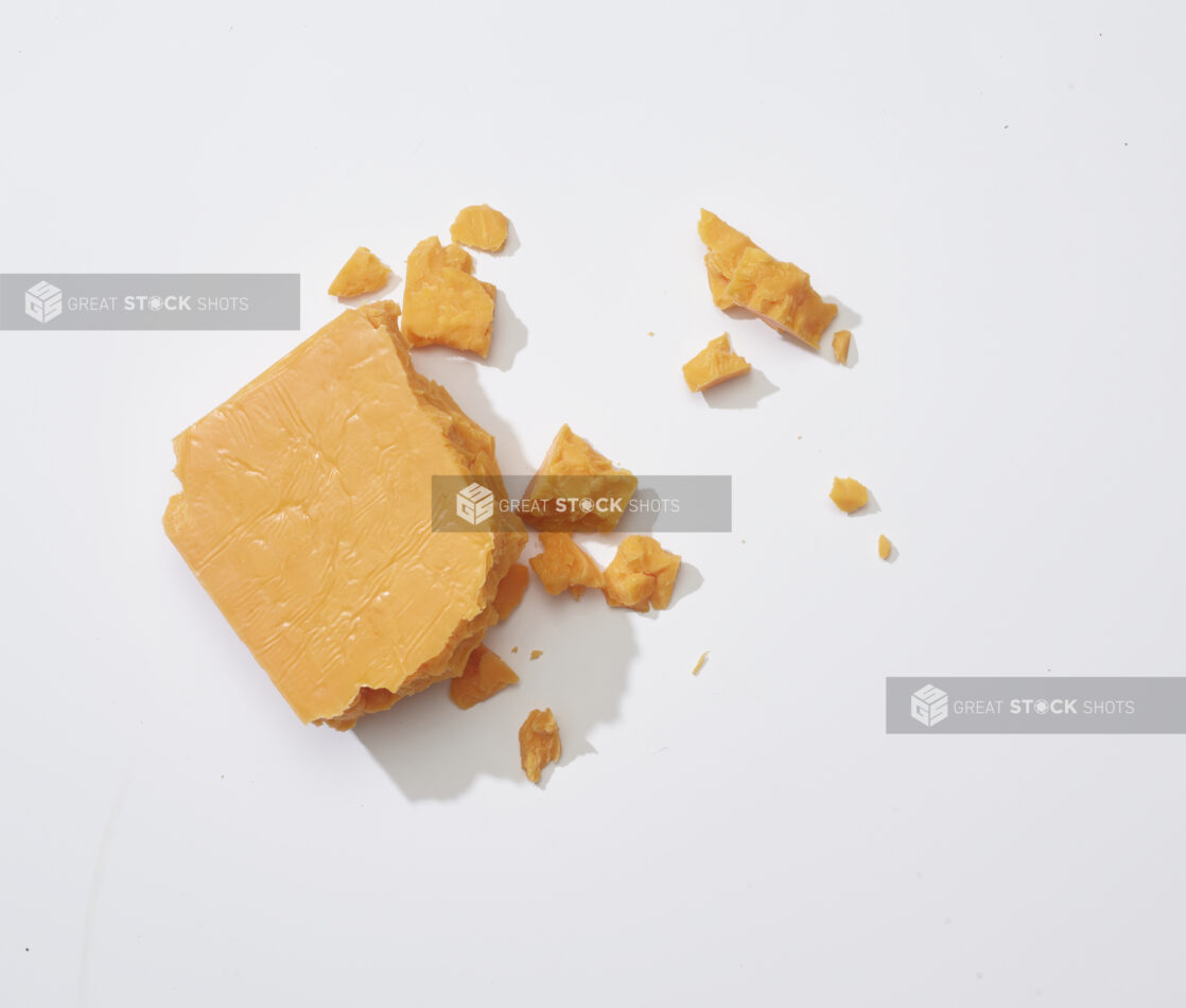 Crumbled aged cheddar cheese on a white background