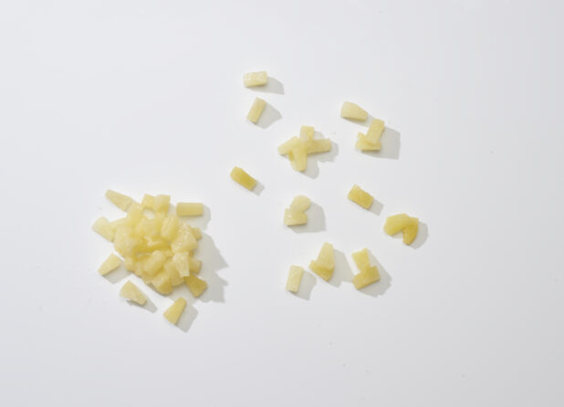 Fresh pineapple chunks on a white background