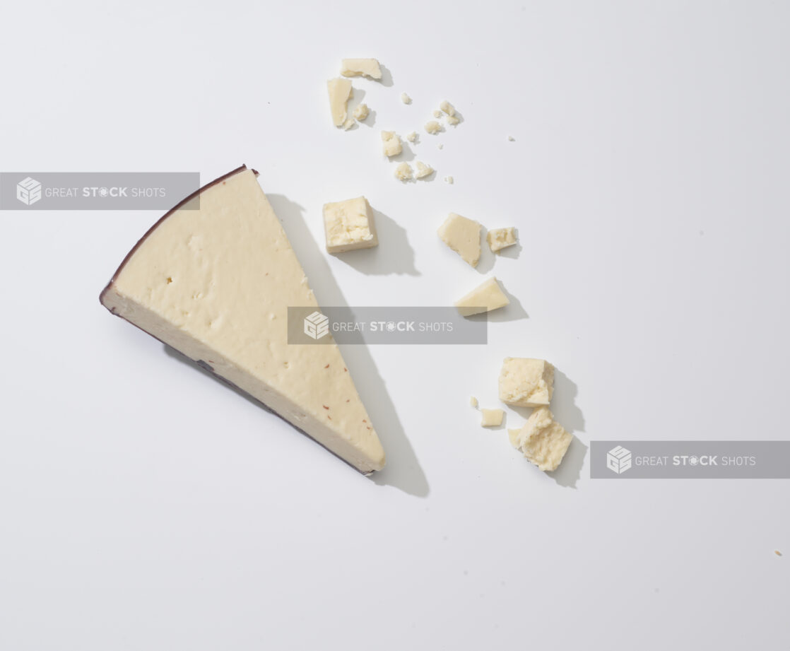 Crumbled artisanal aged cheese on a white background