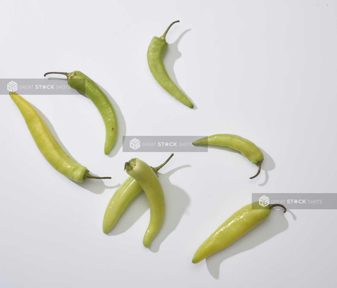 Whole banana peppers on a white background