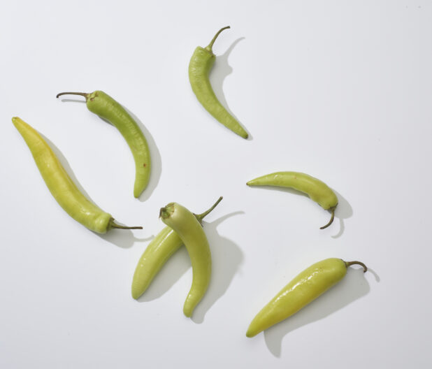 Whole banana peppers on a white background