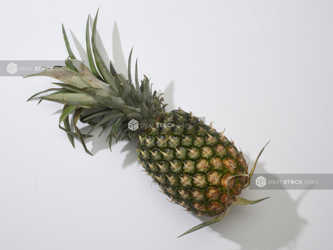 A fresh whole pineapple on a white background