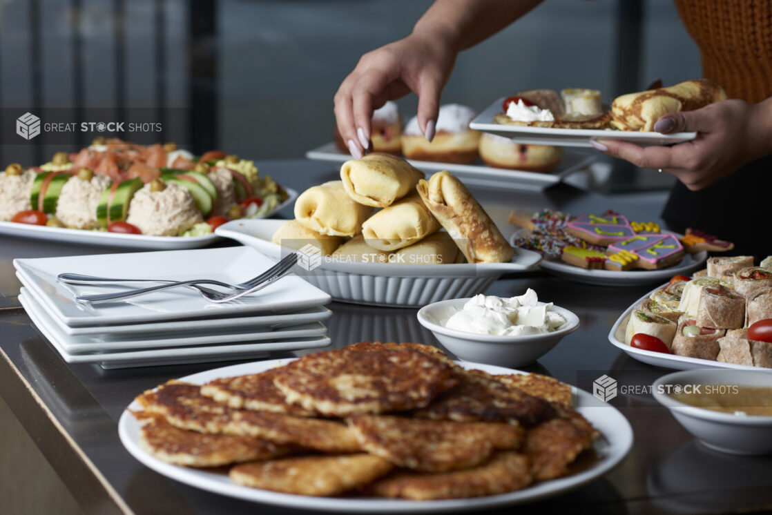 A person taking items from a buffet of Hanukkah food