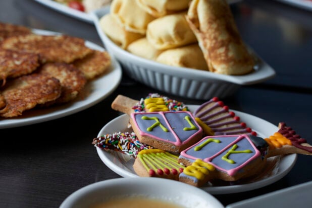 A buffet with decorated cookies and assorted plates of food for Hanukkah
