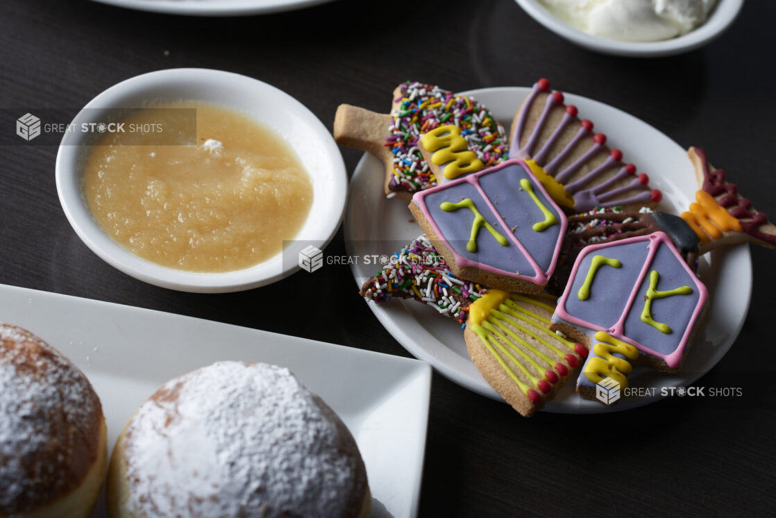 Decorated Hanukkah cookies on a white plate with a dark background